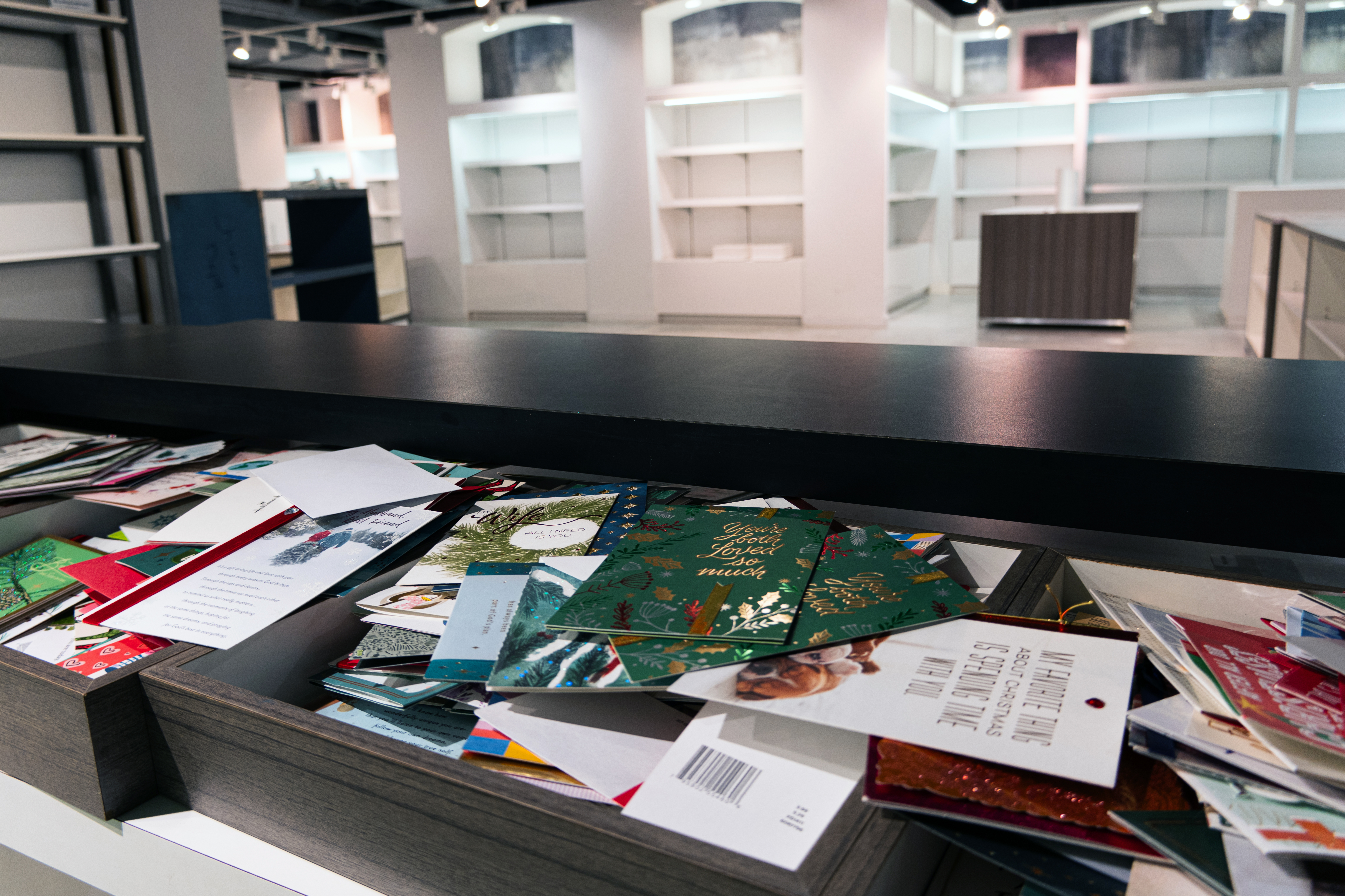 Old Christmas cards spread out across a former retail counter. 