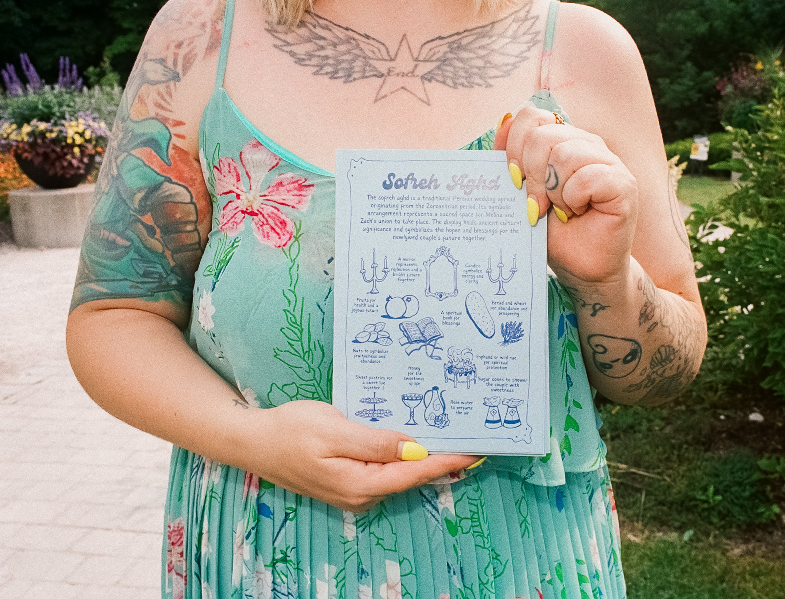 A guest holds a card explaining the Sofreh Aghd ceremony