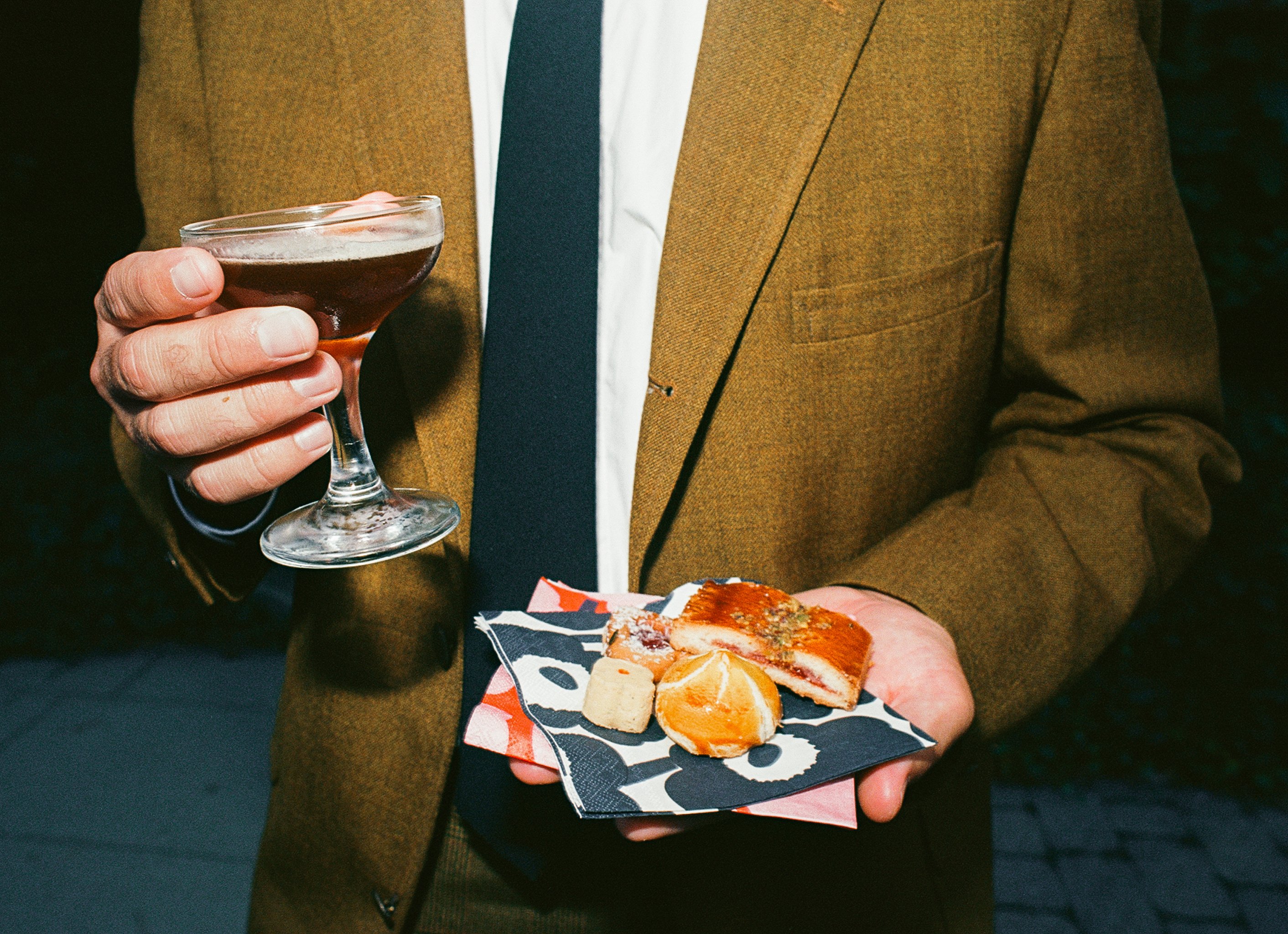 A guest holding food and a drink at Melina and Zach's wedding