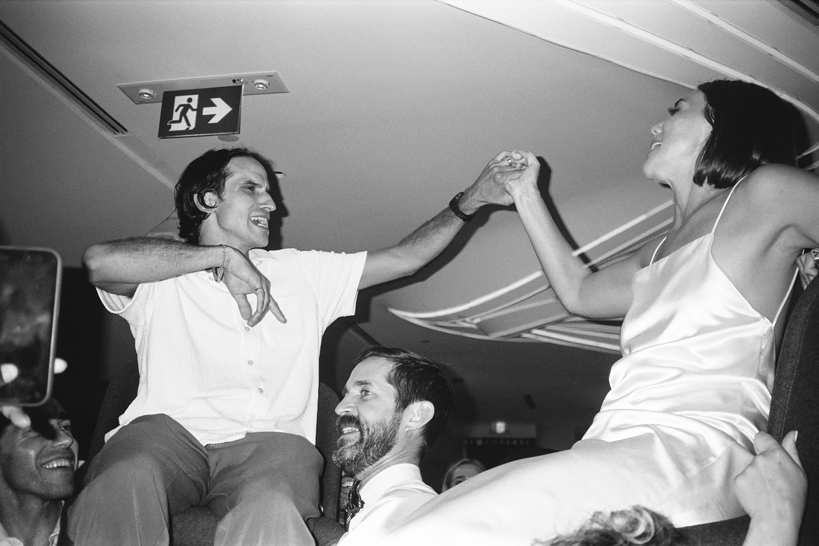 Brjánn and Ryanne dance while being hoisted on chairs by guests.