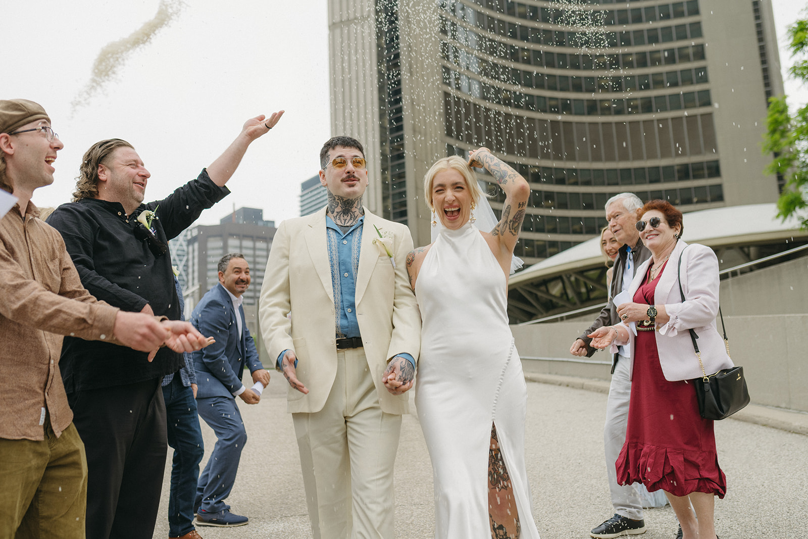 Cassy and Larry walk outside City Hall as guests toss rice in the air