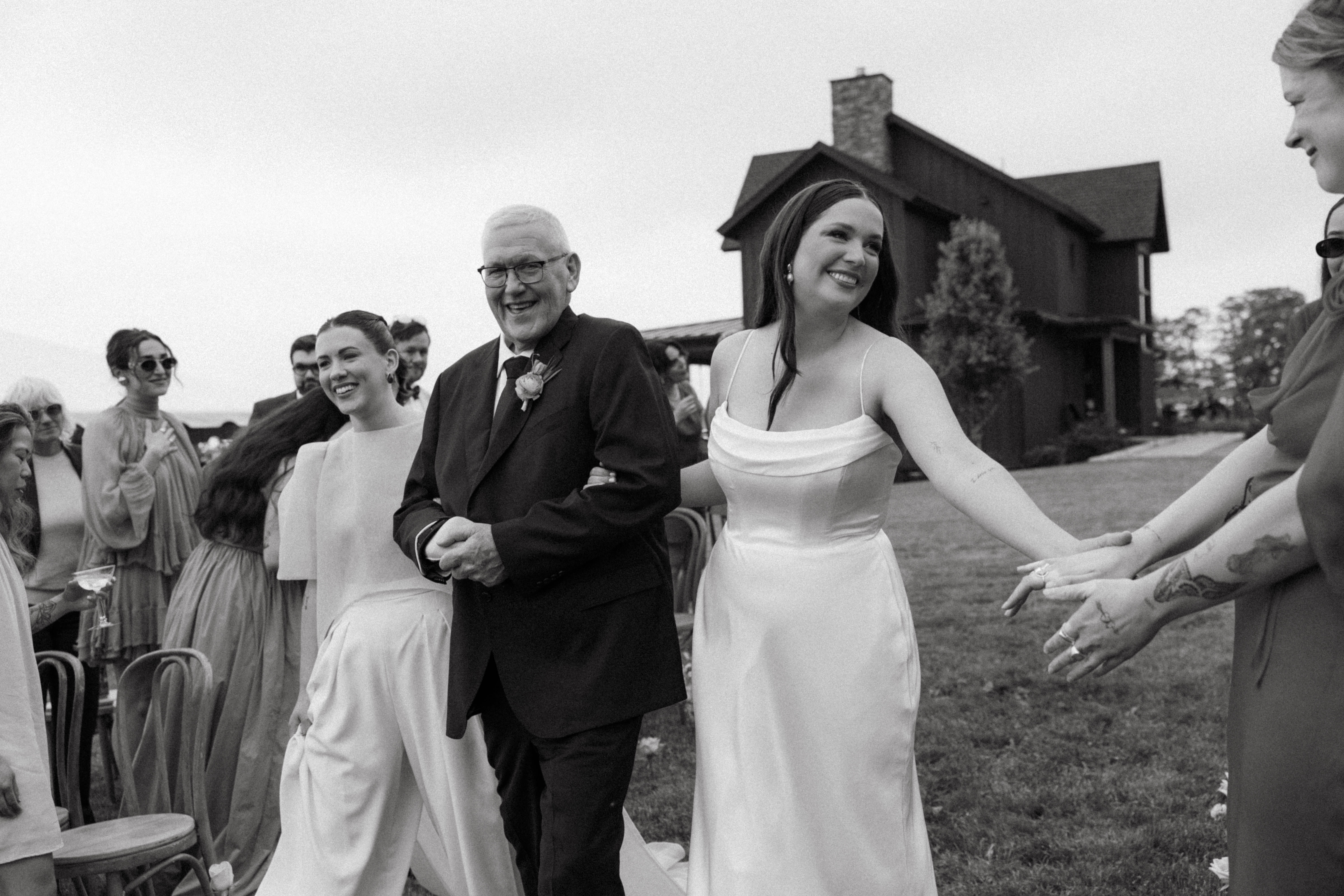 Brides with family walking down the aisle.