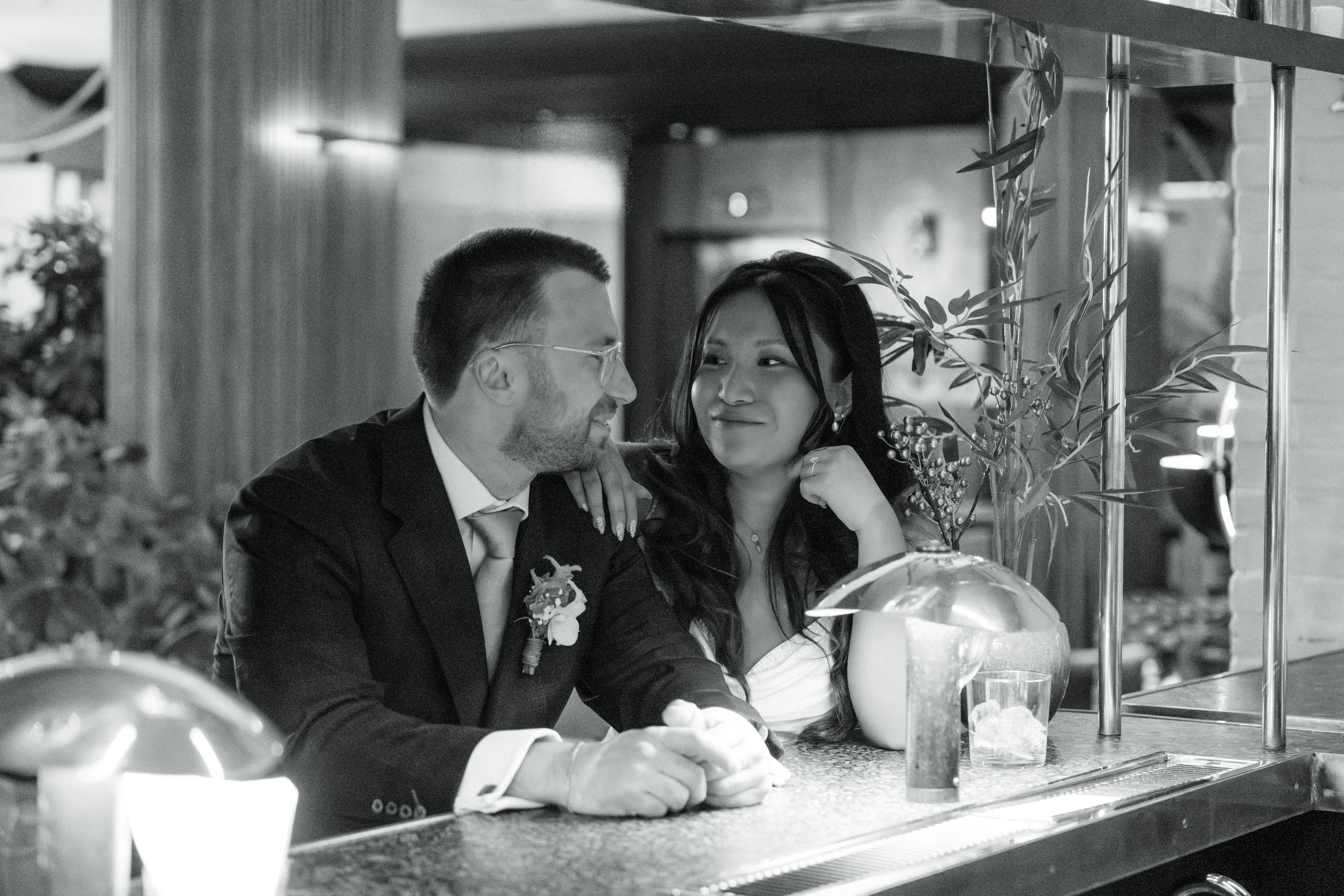 Bride and groom looking at one another conspiratorially