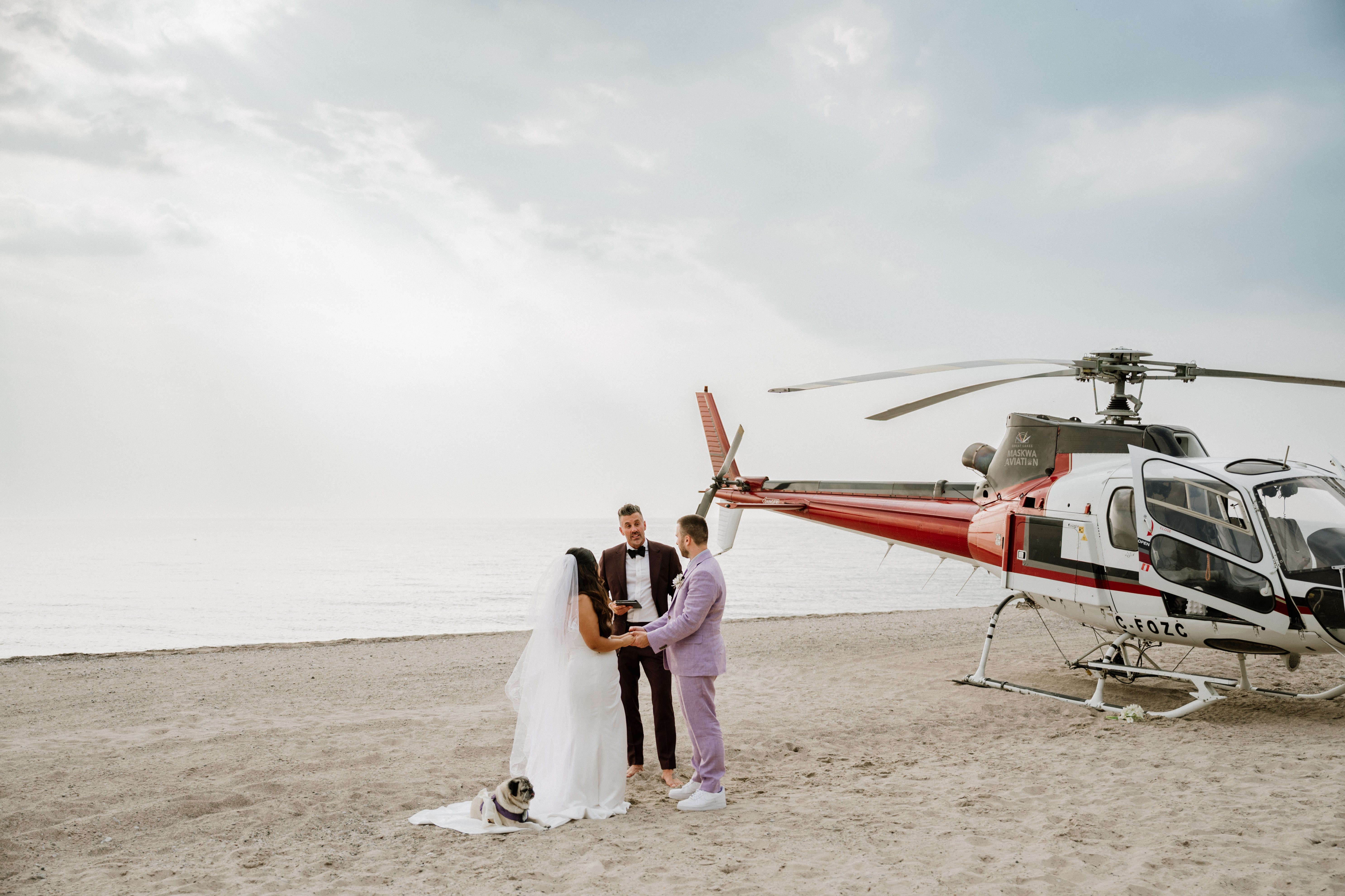 Bride and groom saying vows in front of a helicopter