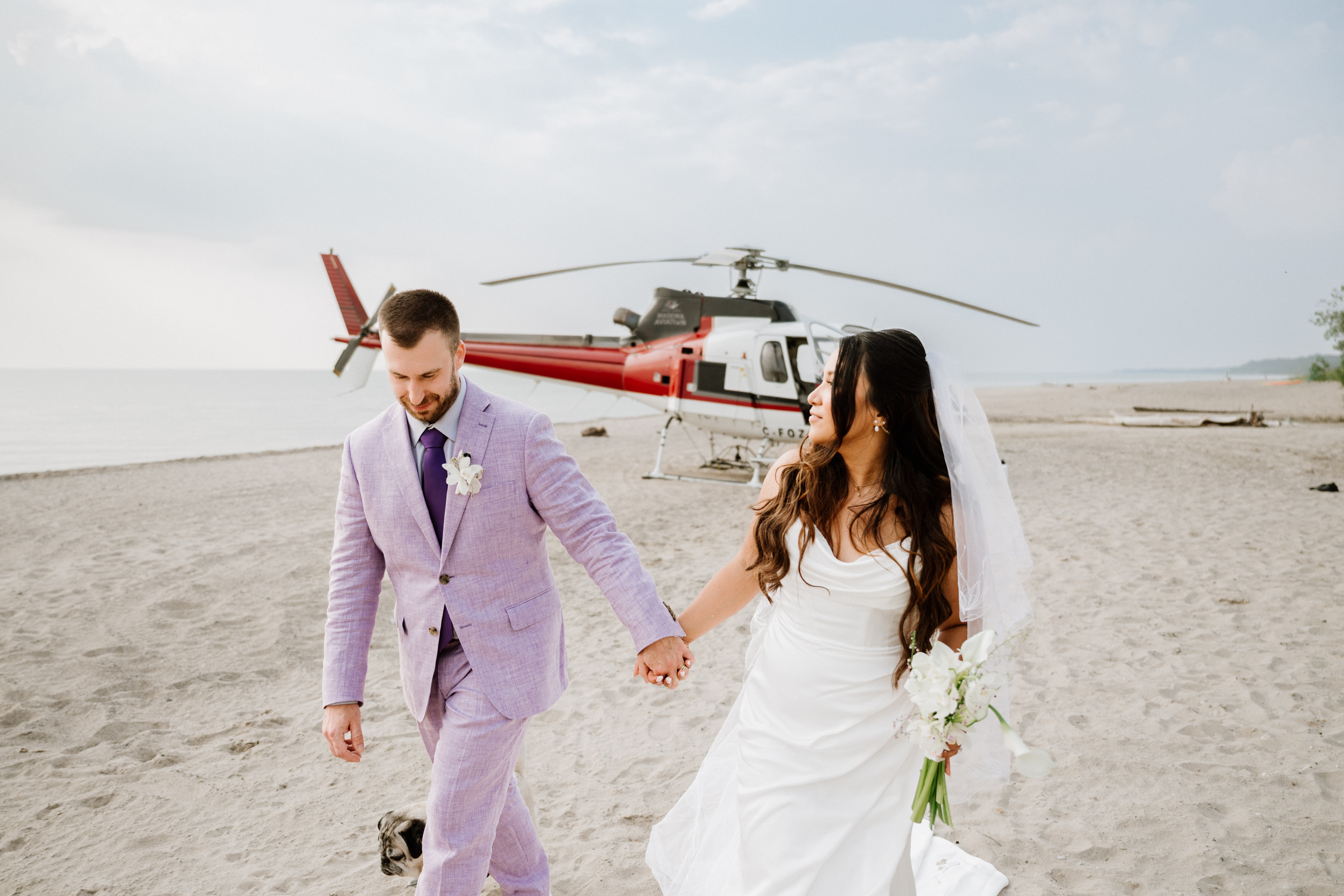Bride and groom in front of a helicopter