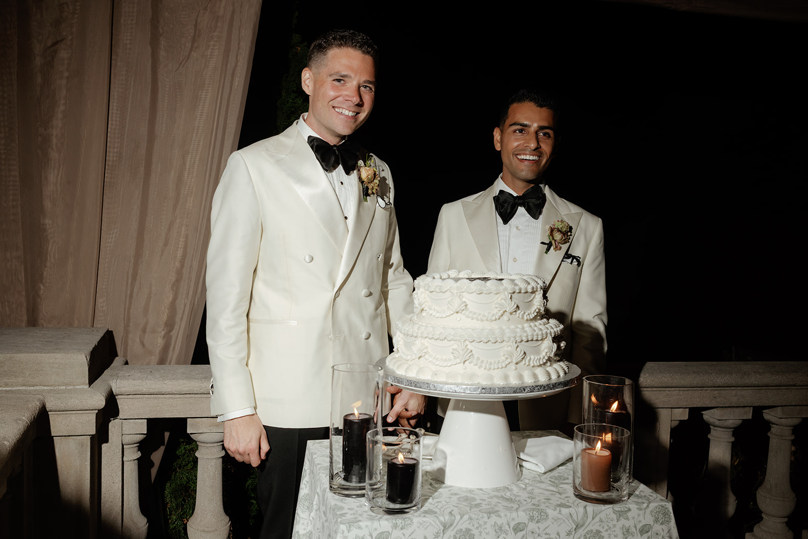 Two grooms cutting cake